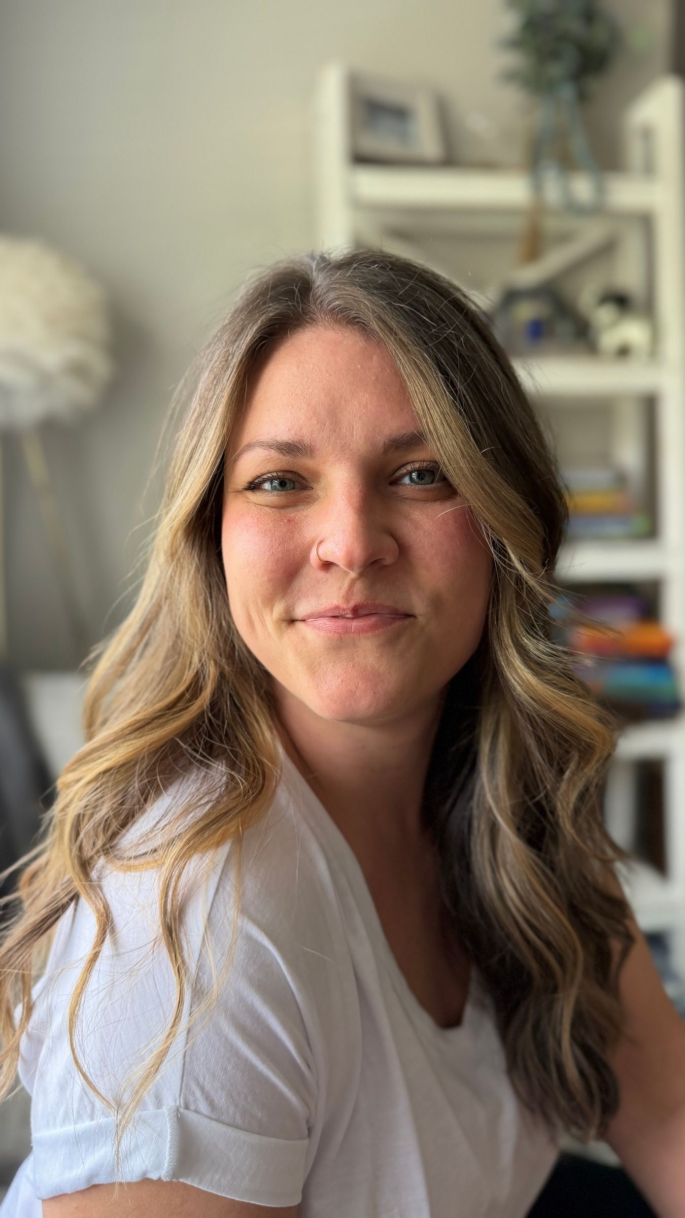 Leah seated indoors in a white shirt