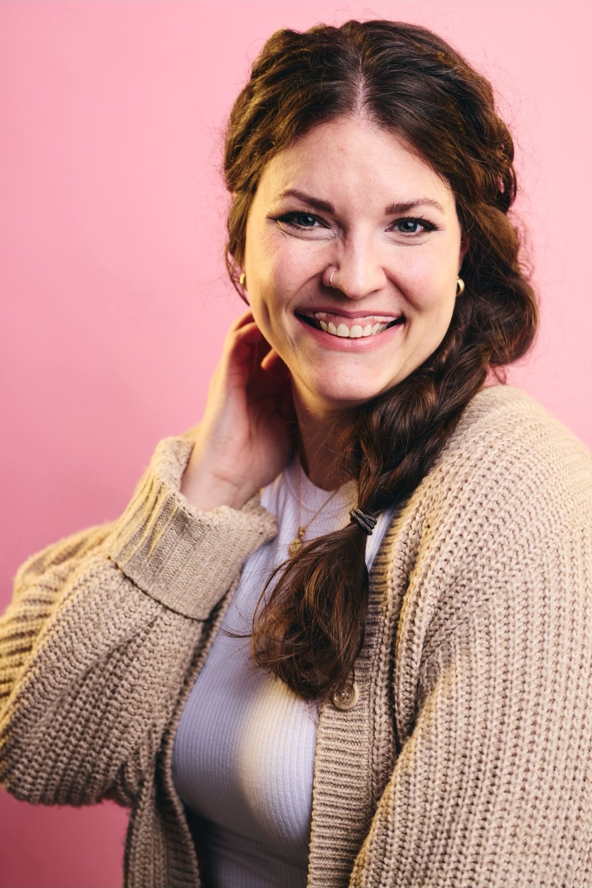 Leah smiling against a pink background